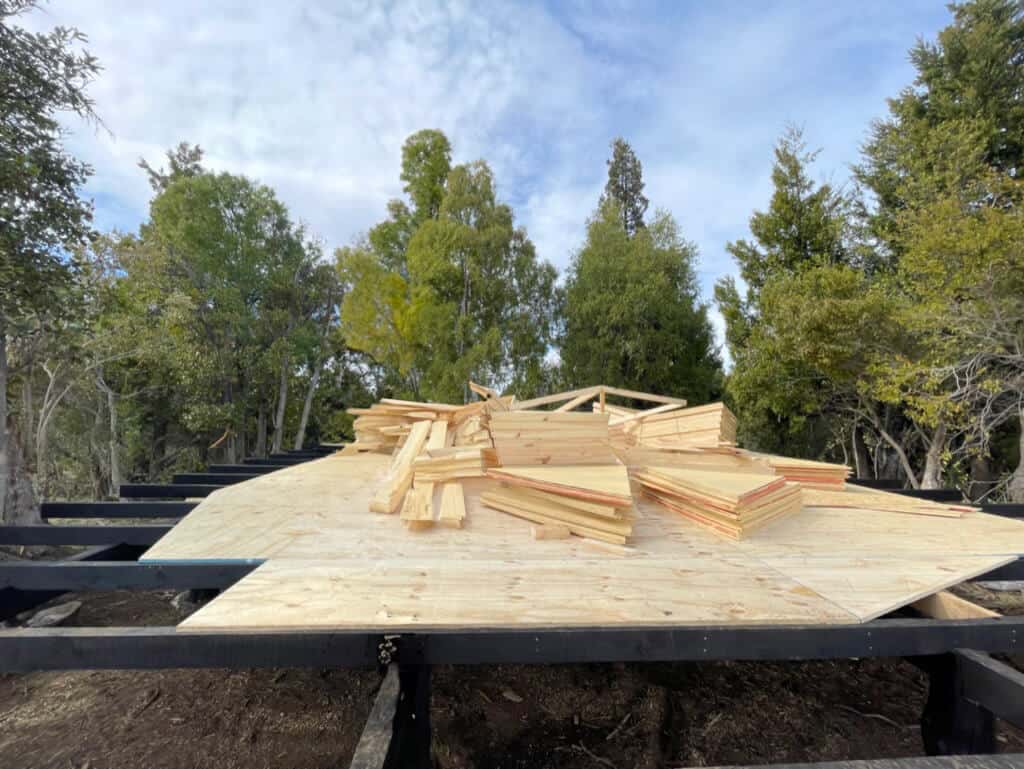 Wooden triangles labeled with letters on plywood for geodesic dome assembly