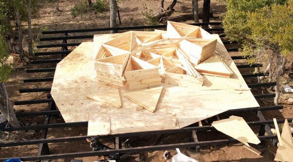 Assembled geodesic triangles stacked on a wooden platform in Patagonia, ready for installation