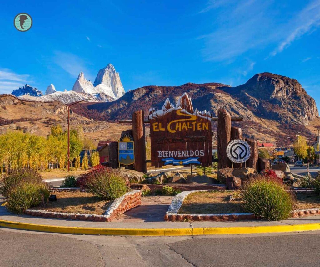 Cartel de bienvenida a El Chaltén con el Fitz Roy al fondo en un día soleado